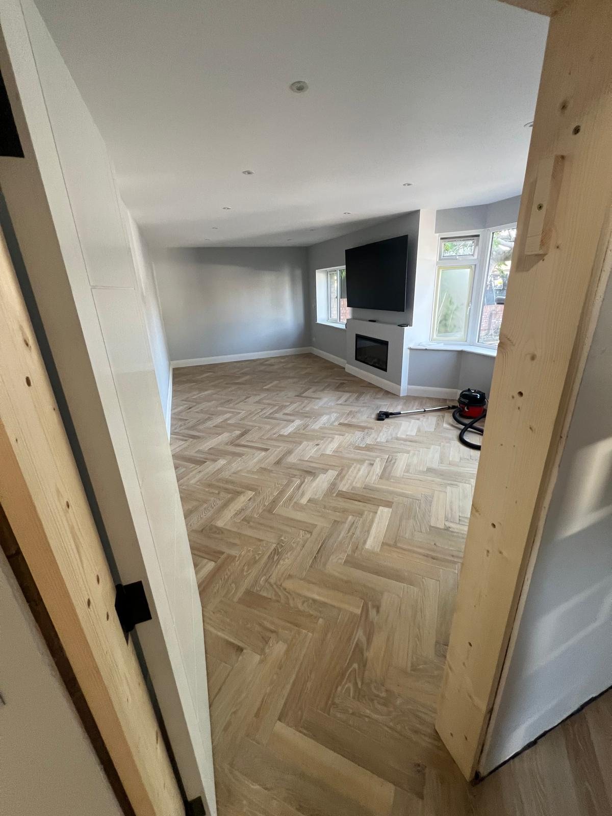 Completed herringbone flooring in a refurbished living room